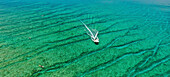 Aerial view of beautiful turquoise ocean with a boat on a pristine coastline,Maldives