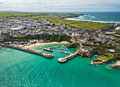 Aerial view of Newquay harbour with fishing boats moored. Fistral beach and Newquay Town can be seen in the background,Cornwall,United Kingdom