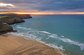 Luftaufnahme von Surfern bei Sonnenuntergang, Perranporth Beach, Ligger Bay, Cornwall, UK