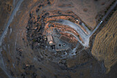Aerial view of the ancient Yuksek church on a hill with a winding road in a beautiful rural landscape,Guzelyurt,Turkey