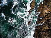 Luftaufnahme von dramatischer stürmischer See und felsigen Klippen in der Nähe der Knysna Heads in Knysna, Westkap, Südafrika