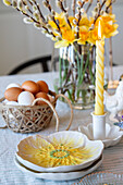 Easter decorated table with candle, pussy willows, daffodils and crocuses