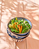 Bowl mit frischem Gemüse und Frischkäsebällchen