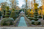 Frostige Wintergartenlandschaft mit geschnittenen Buchsbaumformen und Pavillon
