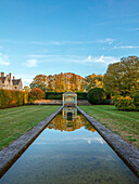 Teich mit Pavillion und Buchsbaumhecken im Herbstgarten
