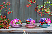Hortensie, Dahlie und Hagebutten (Rosa multiflora) in Schalen arrangiert