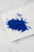 Blaues Spirulina-Pulver auf Marmorplatte
