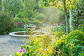 Frühlingsgarten mit Tulpen und Springbrunnen im April