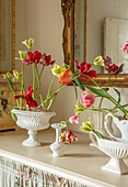 Tulpenarrangement in weißen Constance-Spry-Vasen auf Tisch im Blumenraum