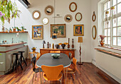 Essbereich mit Holzstühlen und Spiegelwand im Loft mit Zimmerpflanzen