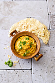Hummus with red curry paste, lime juice and papadam