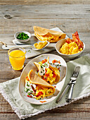 Breakfast pancakes with scrambled eggs, bacon and cheese