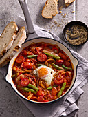 Bell pepper and tomato stew with beans, sausage and egg