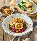 Potato roll with smoked pork filling on red cabbage