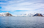 Arktischer Ozean, Svalbard-Inseln, Norwegen. Weitwinkel-Landschaftsansicht einer eisigen Berginsel und eines Gletschers im Meer.