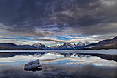 Wolken spiegeln sich in einer Öffnung im Eis des Lake McDonald im Glacier National Park, Montana, USA.