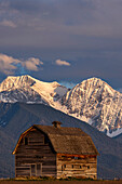 Old wooden barn and Mission Mountains near Pablo, Montana, USA.