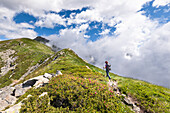 A girl is walking along the Alta Via n. 1 of Aosta Valley towards the Coda Refuge (Pollone, Biella province, Piedmont, Italy, Europe) (MR)