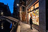 Woman looking a store window of a typical shop of Venice, Veneto, Italy, Europe