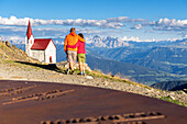 Back view of hikers admiring Dolomites from Latzfonser Kreuz, Lazfons, Chiusa, Bolzano district, South Tyrol, Italy, Europe.