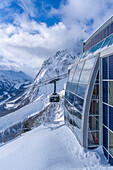View of snow covered Aosta Valley, mountains and Skyway Monte Bianco cable car in winter, Courmayeur, Aosta Valley, Italian Alps, Italy