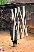 Woman making weaving warp, from Akha Puli tribe living in village in the mountains surrounding Muang La, Oudomxay Province, northwestern Laos