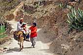 Berber family riding a donkey in the Addouz valley, High-Atlas, Morocco