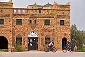 Bike riders in front of the Auberge-restaurant in the village of Telouet, Ouarzazate Province, region of Draa-Tafilalet, Morocco