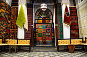 Shop interior with stacks of vibrant handwoven Moroccan rugs and carpets displayed in a traditional shop in Fes, Morocco