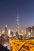 Dubai skyline at sunset with Burj Khalifa, the world tallest building and Sheikh Zayed road traffic, Dubai, United Arab Emirates
