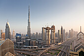 Dubai skyline at sunset with Burj Khalifa, the world tallest building and Sheikh Zayed road traffic, Dubai, United Arab Emirates