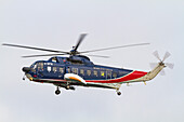 British International helicopter flying over the outer harbor of Stanley on East Island, Falkland Islands