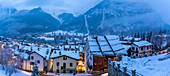 View of the snow covered town centre and mountainous background in winter, Courmayeur, Aosta Valley, Italy