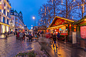 View of cafes, bars and Christmas market on Karl Johans Gate during winter at dusk, Oslo, Norway, Scandinavia