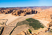 Aerial view from helicopter, of a farm in an ancient oasis in the desert with canyons of the Ashar Valley,AlUla, Medina Province, Saudi Arabia