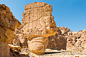 Frau übt Yoga-Posen zwischen Sandsteinfelsen in den Wüstenschluchten des Ashar-Tals, Provinz Medina, Saudi-Arabien
