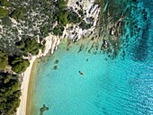 Diaporos island with wild beaches and a kayak on the turquoise water, drone top aerial view, Chalkidiki, Greece