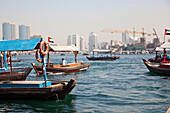 Traditionelle Abra-Fähren, die den Dubai Creek überqueren, der die Stadt in die beiden Hauptteile Deira und Bur Dubai teilt, Dubai, Vereinigte Arabische Emirate