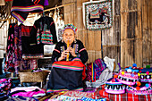 Eine Frau vom Bergvolk der Hmong näht in ihrem Haus im Öko-Dorf Baan Tong Luang bei Chiangmai, Thailand