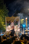 Seville, Spain, Apr 10 2017, Holy Week procession with priostes lighting candles on a beautiful Virgin Mary statue display