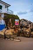 Schild 'Steinschlaggefahr', Felsen und Formationen am Strand Praia Baleal-Norte auf der Insel Baleal, Portugal