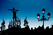 The silhouette of Cristo del Cachorro is seen on his float as it crosses the Triana Bridge during Holy Week in Seville, Andalusia.
