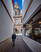 Barocke Fassade der Kirche San Luis, umrahmt von schmalen Mauern, an einem sonnigen Tag in Sevilla, Spanien.