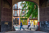 Lebhaftes Stadtbild in der Calle San Jacinto, Sevilla, mit Fußgängerverkehr und Architektur.