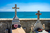 Cimetière Marin overlooks the Mediterranean Sea, featuring tombs and white crosses amidst stunning coastal views in Sète, France.