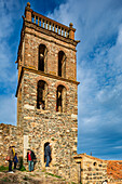 Almonaster, Spain, March 2nd 2013, Ancient minaret of the Caliphal mosque, now the tower of the Christian church in Almonaster la Real, surrounded by visitors and blue skies.