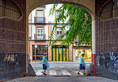 Charming urban street view in Seville with Triana's historical touch and passerby movement.