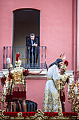 Seville, Spain, Apr 2 2010, During Holy Week in Seville, a man watches the procession of Nuestro Padre Jesús del Silencio from his balcony, embracing tradition.