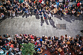 Seville, Spain, Jan 5 2017, Overhead view of a crowd gathered on a cobblestone street awaiting a festive parade.