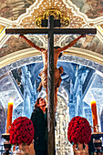 Seville, Spain, Feb 26 2018, A woman staring at the face of Cristo del Calvario, deeply engaged in devotion at Magdalena church in Seville, Spain.